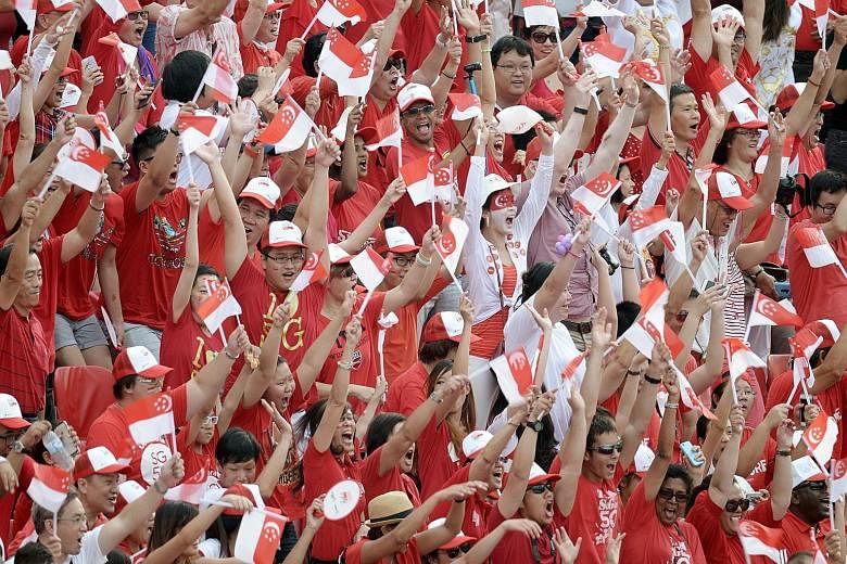 The crowds cheering as they do the Kallang Wave at the Padang. More than 26,000 people watched the parade at the Padang, while another 25,000 caught the action at The Float.