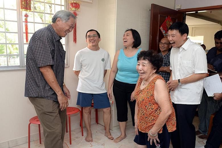 Defence Minister and Bishan-Toa Payoh GRC MP Ng Eng Hen (far left) and potential new PAP candidate Chee Hong Tat (left, in white shirt) sharing a laugh with resident James Tan (in blue shorts), 34, and his family during a house visit in the Balestier