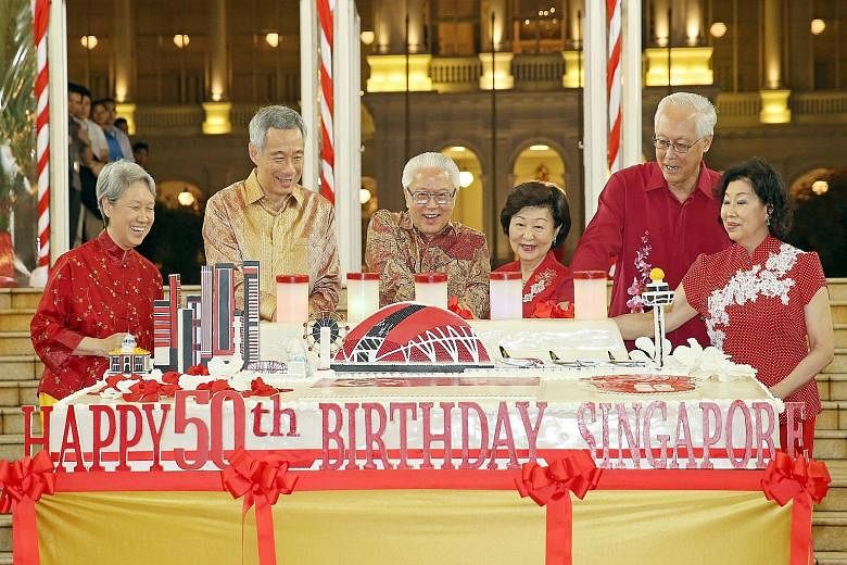 President Tony Tan Keng Yam and his wife, Mrs Mary Tan (centre) are joined by Prime Minister Lee Hsien Loong and his wife, Madam Ho Ching (left), and Emeritus Senior Minister Goh Chok Tong and his wife, Madam Tan Choo Leng (right), in cutting a giant
