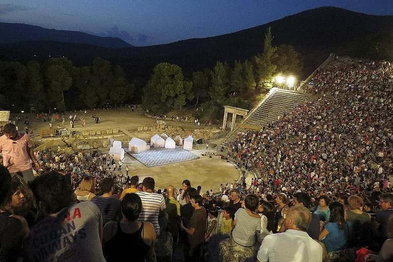 Spectators pack the ancient Greek amphitheatre of Epidaurus for a performance of Aristophanes' play Ecclesiazusae, or The Assembly Women.