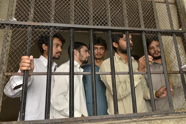Accused gang members in a police lock-up in Husain Khan Wala village, 55km south-west of Lahore. The police have arrested 12 people after media reports on the alleged abuse led to a public outcry.