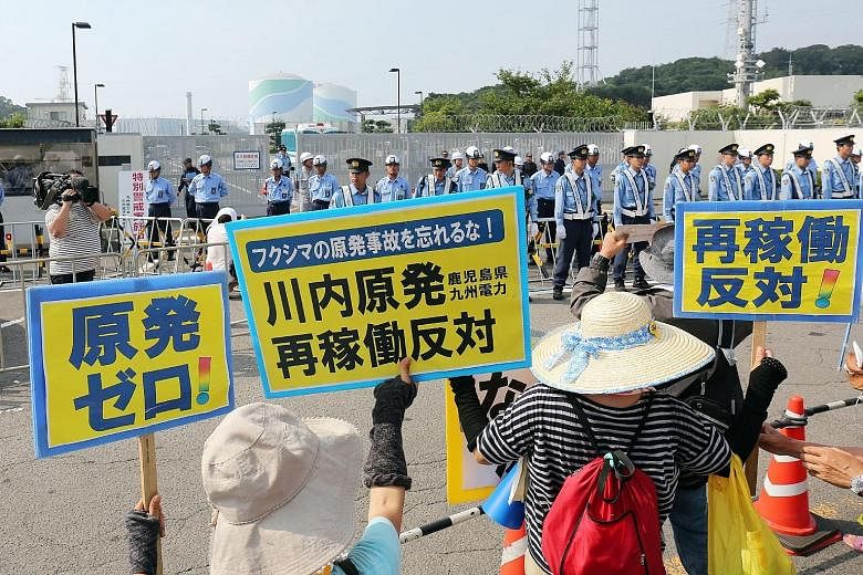 Protesters rallying with posters yesterday against the restart of a nuclear reactor at Kyushu Electric Power's Sendai power plant in Kagoshima prefecture. Japan is set to restart the mothballed reactor today, the first time in two years, as anti-atom