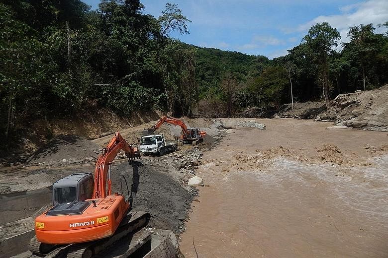 Workers clearing the silt after heavy mudflow into a water intake point in Sabah's Sungai Liwagu forced it to shut down. Heavy mudflows from Mount Kinabalu continue to torment villagers, two months after an earthquake that killed 18 people. The mudfl