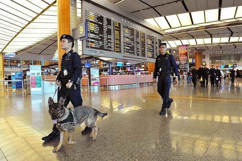 Staff Sergeant Joshua Lo, 32, seen handling German shepherd Kora, and Senior Staff Sergeant Koh Eng Ann, 37, patrolling Changi Airport's Terminal 2 on Saturday. The dogs sniff out drugs, firearms and bombs to keep Singapore safe. (Left) Staff Sergean