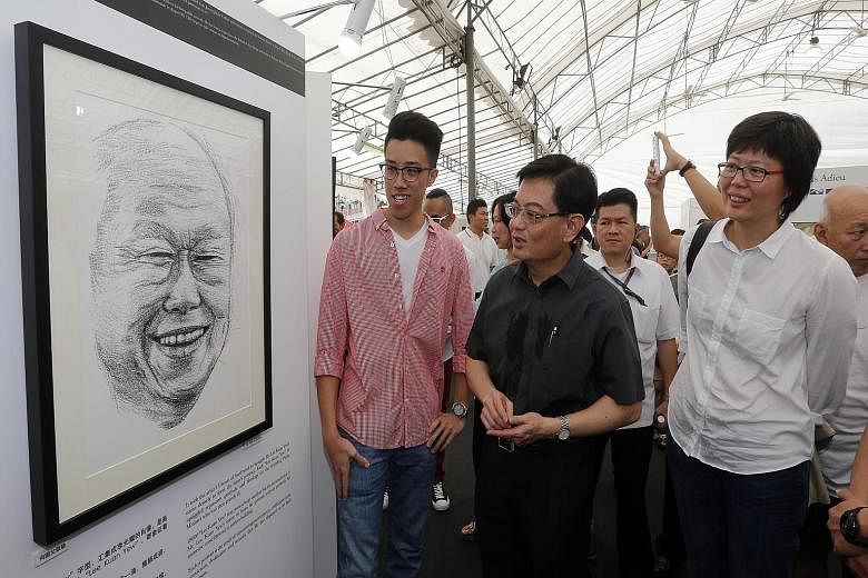 Above: Mr Heng Swee Keat (centre) viewing a portrait of Mr Lee Kuan Yew with artist Ong Yi Teck (left) and Lianhe Wanbao editor Lee Huay Leng. Left: A book on the outpouring of grief after Mr Lee died.