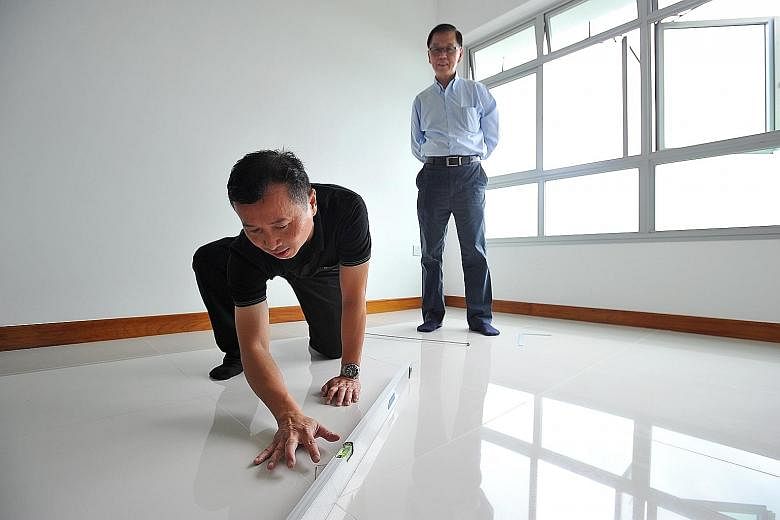 BCA assessor John Koh inspecting the floor of a new BTO flat in Fernvale Street. Conquas scores have been rising, said HDB.