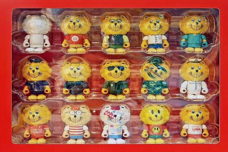The queue for the Singa figurines at the Singapore Kindness Movement gallery. (Above) A set of 15 goes for $300, while individual Singas are sold at $10 each. The most popular Courtesy Lion is the NDP Singa (bottom right), which wears a white s