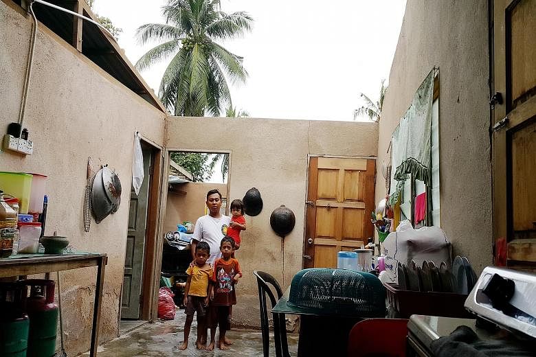 Malaysian labourer Mohd Ridzuan Abdul Aziz, 28, and his three young children inside their roofless home in Kampung Permatang Pasir, Malacca. Bad weather last week destroyed the house's roof. He said community leaders and two NGOs have offered assista