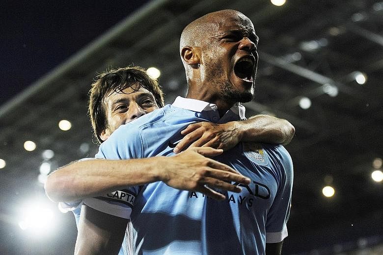 Manchester City's Vincent Kompany (right) celebrates with team-mate David Silva after scoring against West Bromwich Albion in the decisive 3-0 win on Monday.