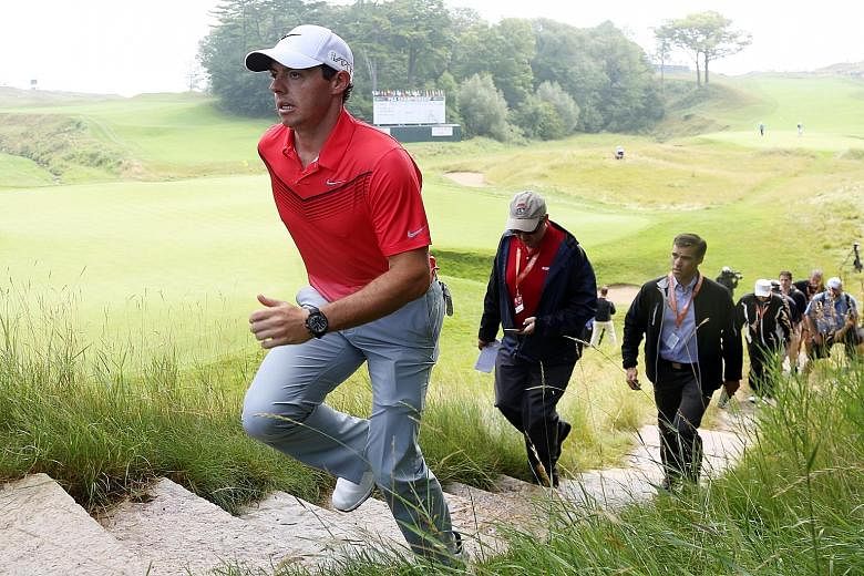 Defending champion Rory McIlroy, returning to competitive golf after more than seven weeks because of an ankle injury, shows no apparent ill-effects as he walks off the 18th green during a practice round for the US PGA Championship at Whistling Strai