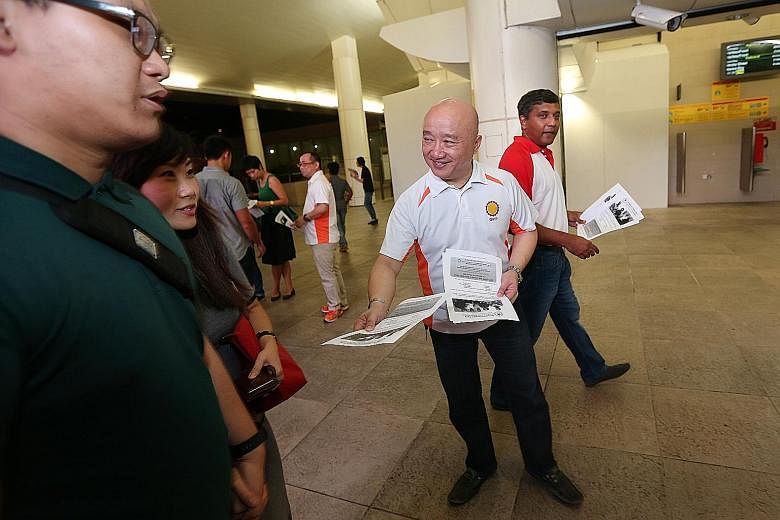 DPP secretary-general Benjamin Pwee distributing fliers at Bishan MRT station. Behind him is SPP central executive committee member Kumar Appavoo. The parties are joining forces to contest Bishan-Toa Payoh.