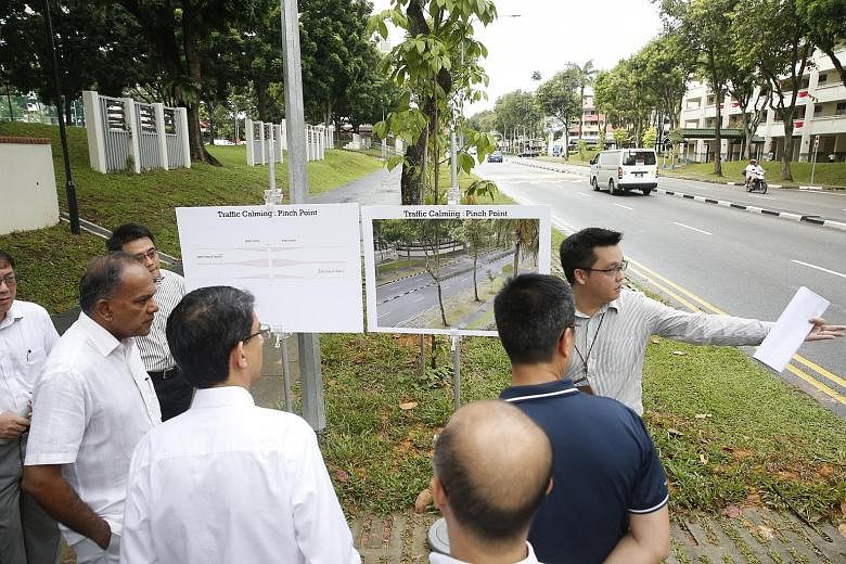 An LTA engineer pointing out to Mr K. Shanmugam (at far left) and Associate Professor Muhammad Faishal Ibrahim (standing next to Mr Shanmugam, with back to camera) the location of the Silver Zone in Yishun Ring Road where a "pinch point" will be buil