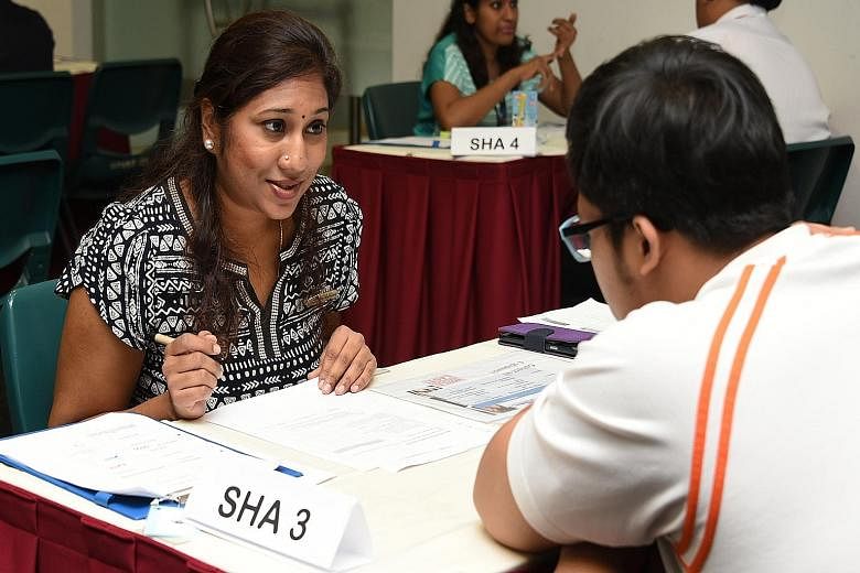 Student health adviser Mageswari D.N. Amaderlingam, 39, offering health advice to a student at ITE College Central yesterday. Advisers help young people to quit smoking or lose weight.