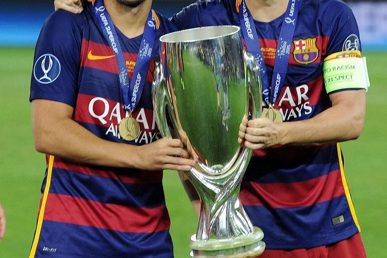 Barcelona forward Pedro Rodriguez (far left) and midfielder Andres Iniesta with the Uefa Super Cup after beating Sevilla 5-4 in Tbilisi.