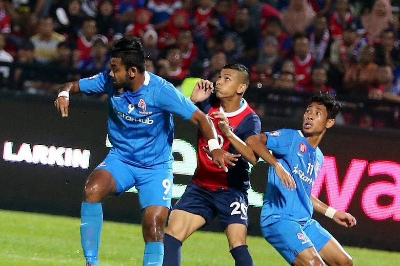 LionsXII right-back Faritz Abdul Hameed (left) and right winger Nazrul Nazari (right) defending against Johor Darul Takzim's Nazrin Nawi yesterday. The defending MSL champions won 1-0 with a goal from Luciano Figueroa.