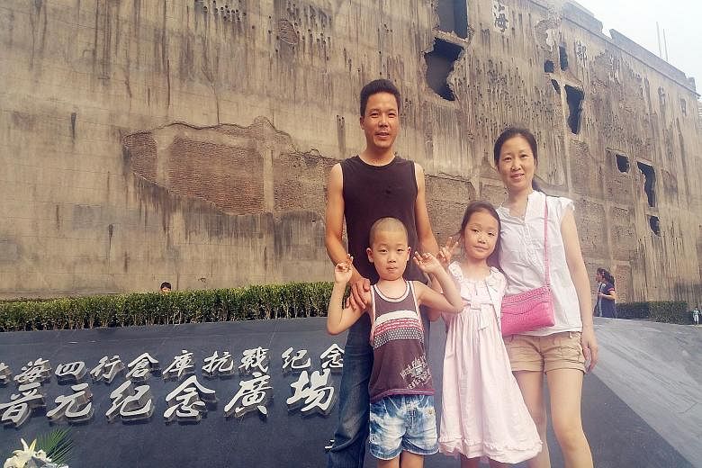 Shanghai resident Lin Yankun with his family outside the restored Sihang warehouse. Holes left by shells and bullets were recreated as part of the restoration of the battle site. Built in 1931, the Warehouse of Four Banks in Shanghai, also known as S