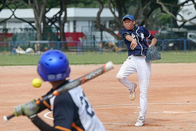 Catholic High School's Aloysius Ong (right) pitches in the Schools National Boys' softball C Division final against St Gabriel's Secondary. Catholic High won 9-3 to take the title for the first time since 2009.