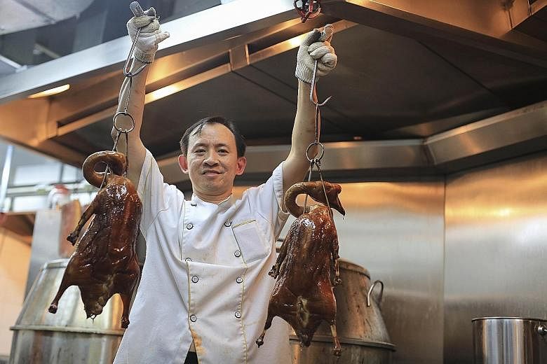 Mr Mervin Goh, owner of London Fat Duck at Scotts Square, which sells about 120 Irish ducks (top) a day. Kam's Roast Goose chef Wong Kwan-sang holding two barbecued geese at its Hong Kong outlet. The roast goose specialist will be opening an outlet i
