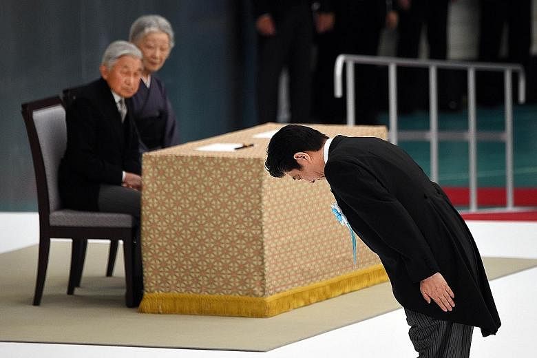 Prime Minister Shinzo Abe bowing before an altar yesterday, during an annual memorial service for war victims in Tokyo, as Emperor Akihito and Empress Michiko looked on.