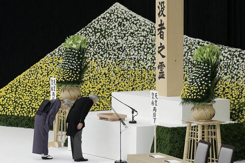 Japanese Emperor Akihito and Empress Michiko bowing before an altar during a memorial service to mark the 70th anniversary of the end of World War II at Nippon Budokan Hall in Tokyo yesterday.