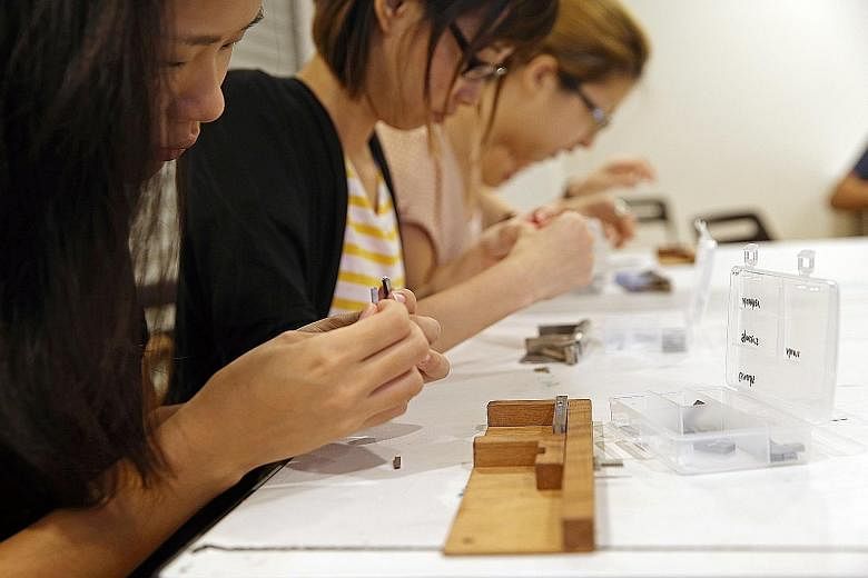 Participants painstakingly putting metal types on a composing stick to make name cards at a hands-on workshop. Titled Printing From The Past: Letterpress And Typesetting, it gave an introduction to letterpress printing and basic typesetting, the tool