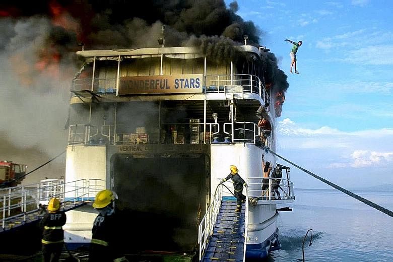A crew member jumping off the ferry Wonderful Stars after it caught fire at the port in Ormoc city, central Philippines, yesterday. All 544 passengers were evacuated safely. More than a month ago, 61 passengers were killed when the Kim Nirvana ferry 