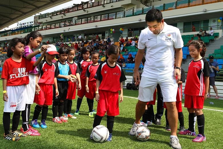 Football Association of Singapore vice-president Bernard Tan joining children aged between six and 12 at the launch of the FAS Grassroots Cubs programme at the Jalan Besar Stadium yesterday. The kids took part in various coaching stations promoting f