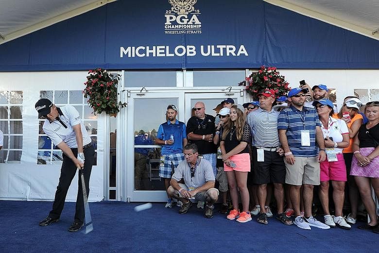 Matt Jones keeps his cool and concentration as he plays from inside a hospitality tent after his drive goes astray during the third round of the PGA Championship. Fans high-fived him after he executed his shot.
