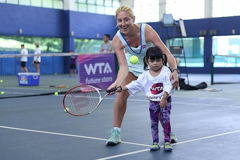 WTA Finals tournament director and vice-president for Asia-Pacific, Melissa Pine, coaching four-year-old Shazia Malika at the WTA Future Stars clinic at Keppel Club.
