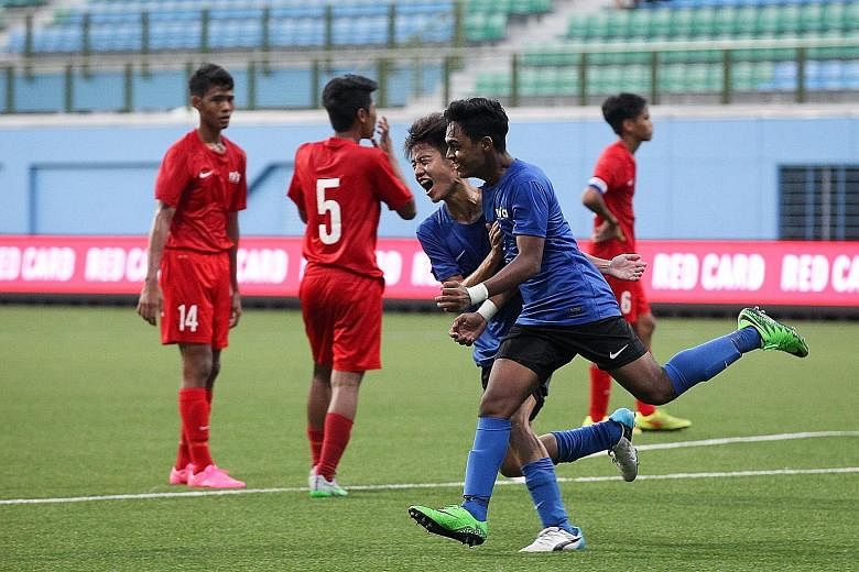 Singapore Under-16's Saifullah Akbar (in green boots) celebrating with team-mate Elliot Ng after scoring the penalty that won the match against the Singapore U-15 team in the Lion City Cup third-place play-off. Both teams' performances came under cri