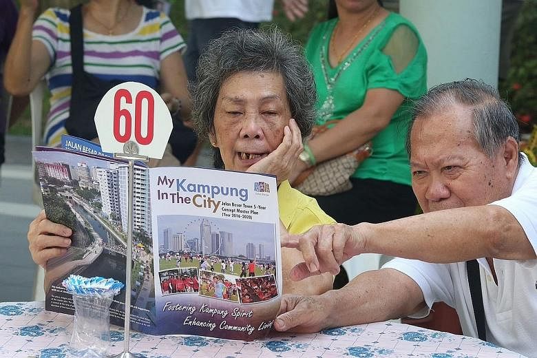 Residents looking at an information booklet on a five-year master plan to rejuvenate Jalan Besar GRC yesterday. They can expect some 200 improvement projects worth $20 million.