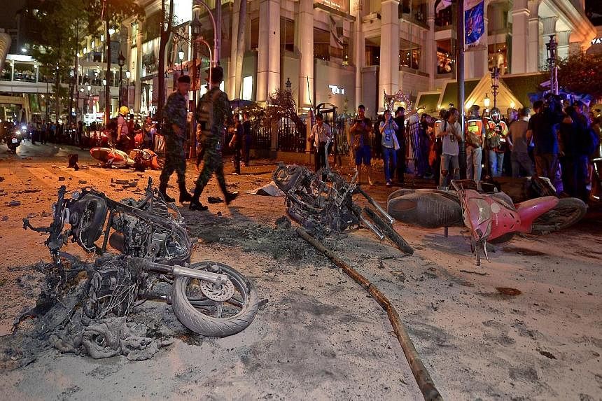 Thai soldiers patrolling the scene of the bomb blast in central Bangkok. The blast came from a planted blomb which went off just metres from the popular Erawan Shrine at about 7pm yesterday, killing at least 16 people and injuring some 80. Body parts