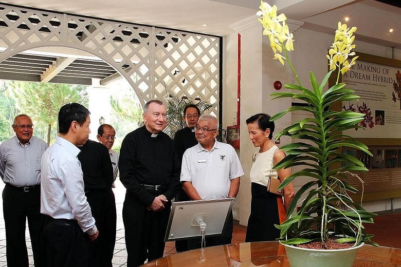 Left: Cardinal Parolin (centre) viewing the Aranda Lee Kuan Yew during a tour of the Botanic Gardens yesterday. Accompanying him were Singapore's Ambassador to the Holy See Barry Desker (far left), NParks chief executive Kenneth Er (second from left)