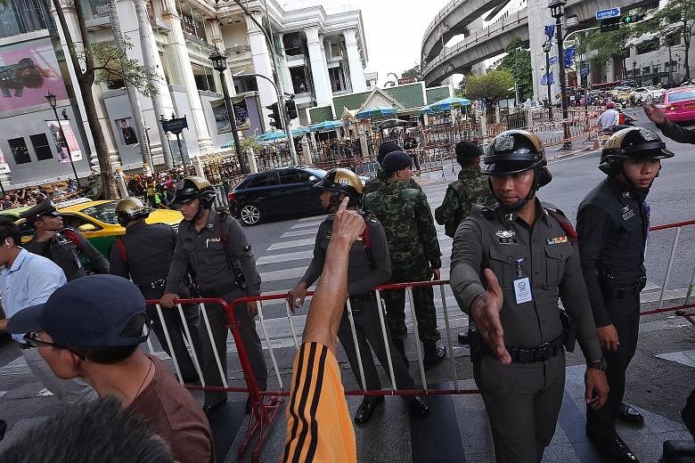 Security personnel keeping the public away yesterday at Bangkok's Erawan Shrine where a bomb went off on Monday night, killing 20 people and injuring another 120. Ms Melisa Liu and her husband Ng Su Teck had travelled to Bangkok with some companions 