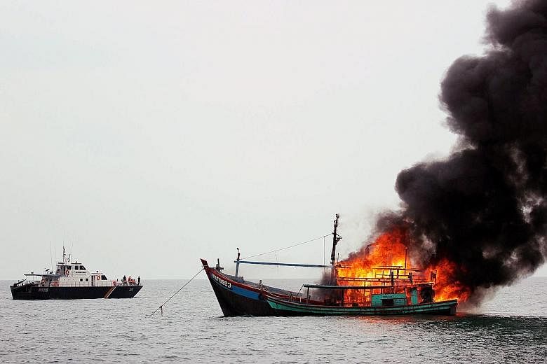 The Indonesian Navy supervising the destruction of a foreign vessel seized for fishing illegally in Indonesian waters near Belawan, north Sumatra, yesterday. According to media reports, Indonesia has sunk foreign boats across its territory as part of
