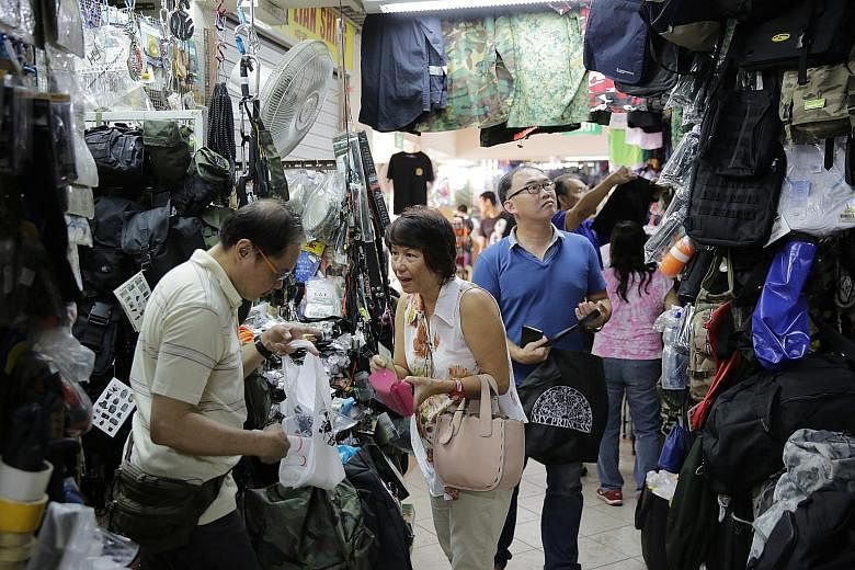 Madam Veronica Chan, 60, buying socks at the Beach Road army market for her son, who is doing his national service in the air force. Only a handful of the shops there still sell army gear, with most of them making the change to sell outdoor gear and 