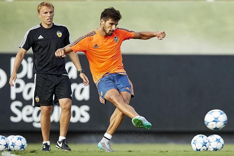 Valencia's assistant manager Phil Neville (left) watching young midfielder Andre Gomes making a pass during training. The Spanish La Liga football club have kept their promising players together in the belief that they will help bring success in Spai