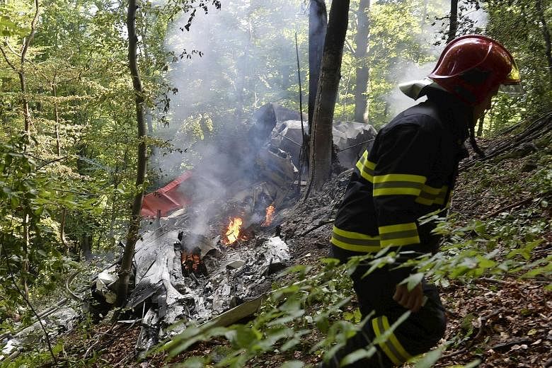 A firefighter at the site where two sport planes with 38 people on board crashed yesterday near the village of Cerveny Kamen in Slovakia, Four pilots and three parachutists died in the mid-air collision.