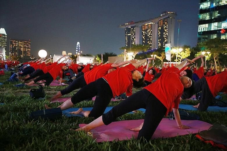 Participants at a mass yoga event at The Lawn @ Marina Bay - an open area above Marina Bay Link Mall. Thursday's fitness event drew about 500 people. It was organised by My Paper, the bilingual newspaper published by Singapore Press Holdings. Places 