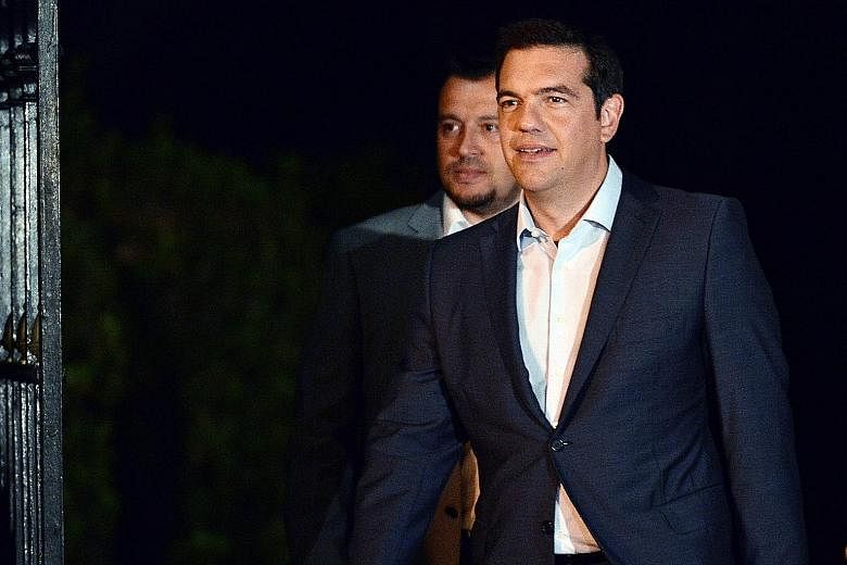Greek Premier Alexis Tsipras (right) leaving the presidential palace in Athens after presenting his resignation on Thursday.