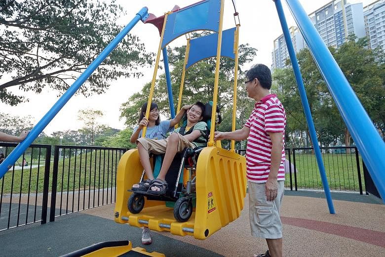 Thirteen-year-old Samuel Chong, who was born with cerebral palsy, plays on a swing for the first time as his parents Amy Teo, 51, and Chong Choon Leong, 49, accompany him at Bishan-Ang Mo Kio Park yesterday. The family travelled from their home in Kh
