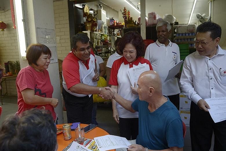 SPP's Lina Chiam and Ravi Philemon (both in white-and-red T-shirts) during the party's walkabout in Bukit Batok yesterday.