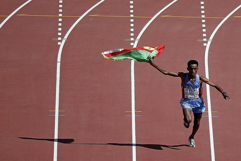Ghirmay Ghebreslassie of Eritrea celebrates as he enters the Bird's Nest stadium to win the men's marathon after taking the lead from the 36km mark.