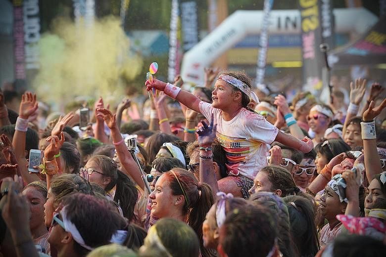 Participant Elizabeth Lyons (top), seven, was one of 9,000 at the Colour Run in Sentosa yesterday. Concerns were raised after a dust explosion in Taiwan in June left at least 10 partygoers dead and hundreds injured.
