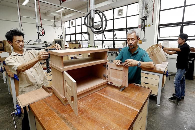 Under the new scheme, skilled foreign craftsmen can be recruited to train locals such as (from left) Mr Chen Teck Wah, Mr Sulaiman Suib and Mr Muhammad Iszad Razali, who graduated last year from a furniture craftsman programme.