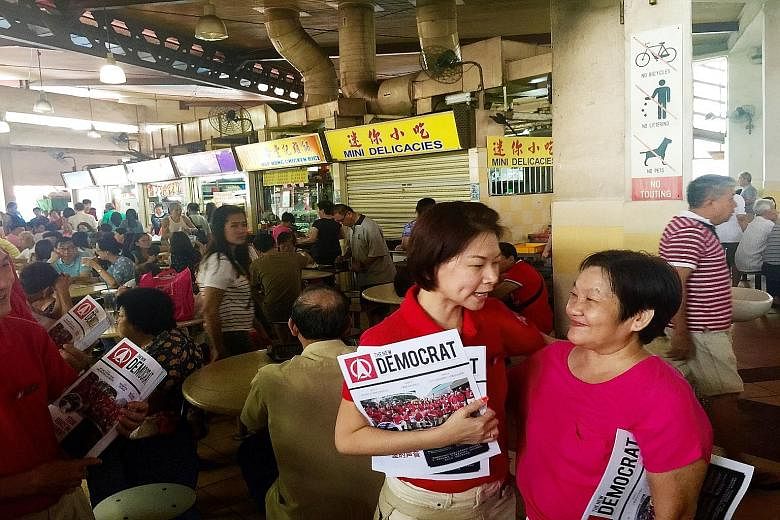 Ms Jaslyn Go (at left) with a resident during a party walkabout at Yuhua Village Market and Food Centre in Jurong East yesterday.