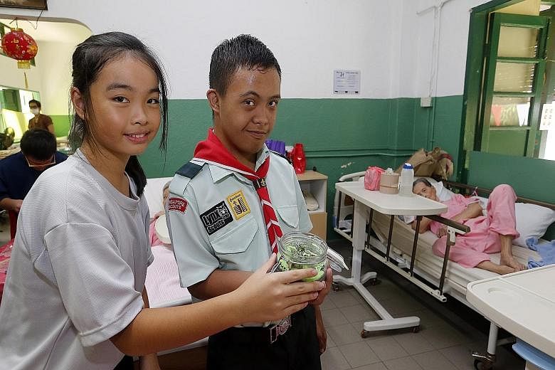 Swiss Cottage Secondary School student Amelie Chan Su Ying, 13 (left), and Minds student Amirul Hidyat, 15, with a terrarium that they made for residents of an old folks' home.
