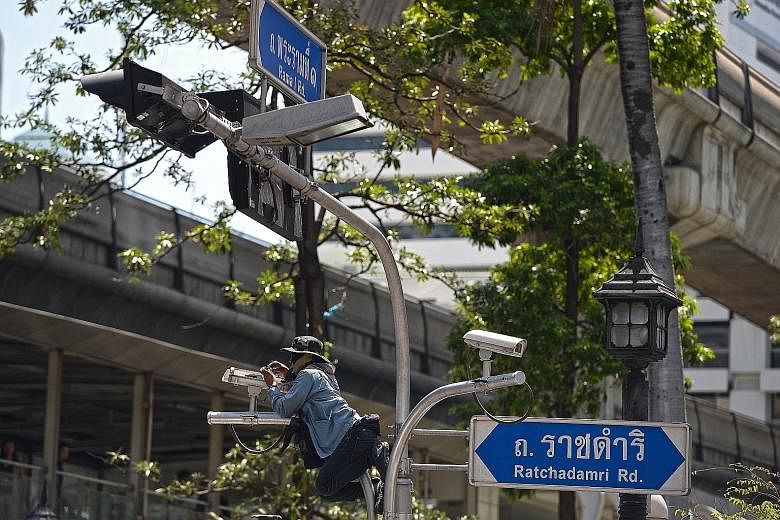 A worker last Thursday fixing a CCTV camera installed above the reopened Erawan Shrine, where 20 people were killed on Aug 17 in a bomb blast. National police chief Somyot Pumpanmuang has claimed that malfunctioning equipment was hampering investigat