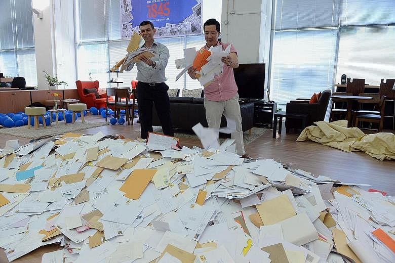 ST editor Warren Fernandez (far left) and sports editor Marc Lim picking entries from the almost 65,000 received. One winner will be drawn from the shortlist of 2,000 for the Land Rover Discovery Sport vehicle, which is the ST170 Treats contest's big