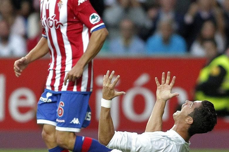 Sporting Gijon's players like Isma Lopez (left) are not overawed by Real Madrid's stars like Cristiano Ronaldo as they hold out for a goalless draw, heaping pressure on new Real manager Rafael Benitez.